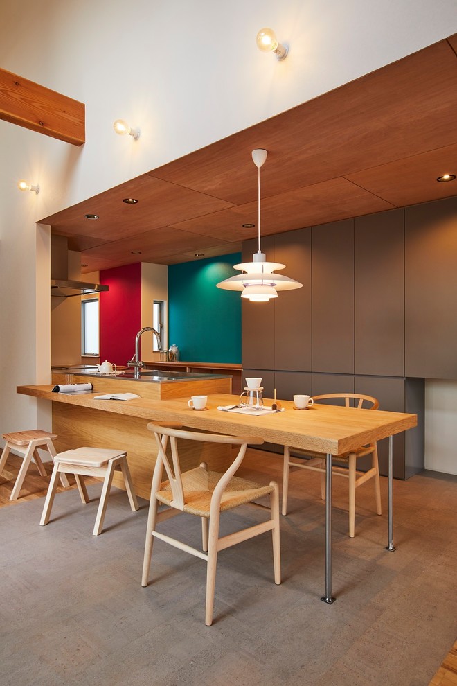 Mittelgroße Moderne Wohnküche ohne Kamin mit brauner Wandfarbe, Korkboden und grauem Boden in Sonstige