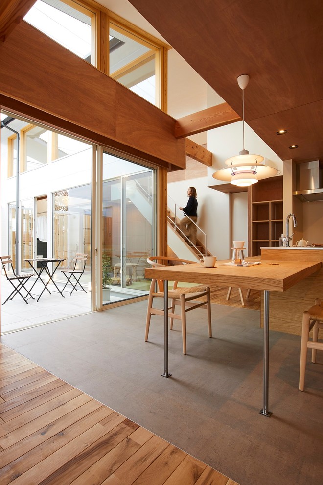 Свежая идея для дизайна: кухня-столовая среднего размера в стиле модернизм с коричневыми стенами, пробковым полом и серым полом - отличное фото интерьера