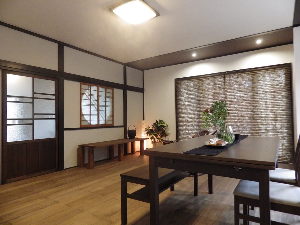 Offenes, Kleines Asiatisches Esszimmer ohne Kamin mit weißer Wandfarbe, braunem Holzboden und braunem Boden in Sonstige