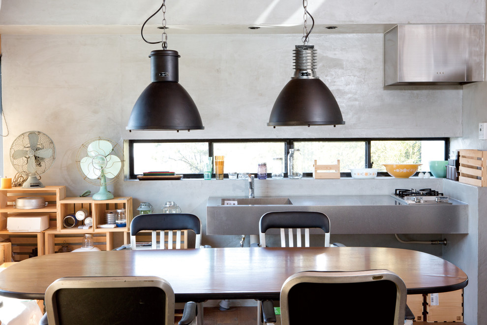 Cette image montre une salle à manger urbaine avec un mur gris et un sol marron.