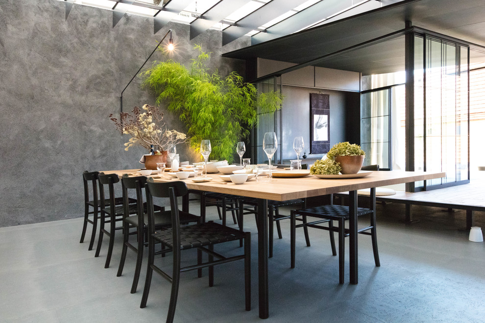 Réalisation d'une salle à manger design avec un mur gris et un sol gris.