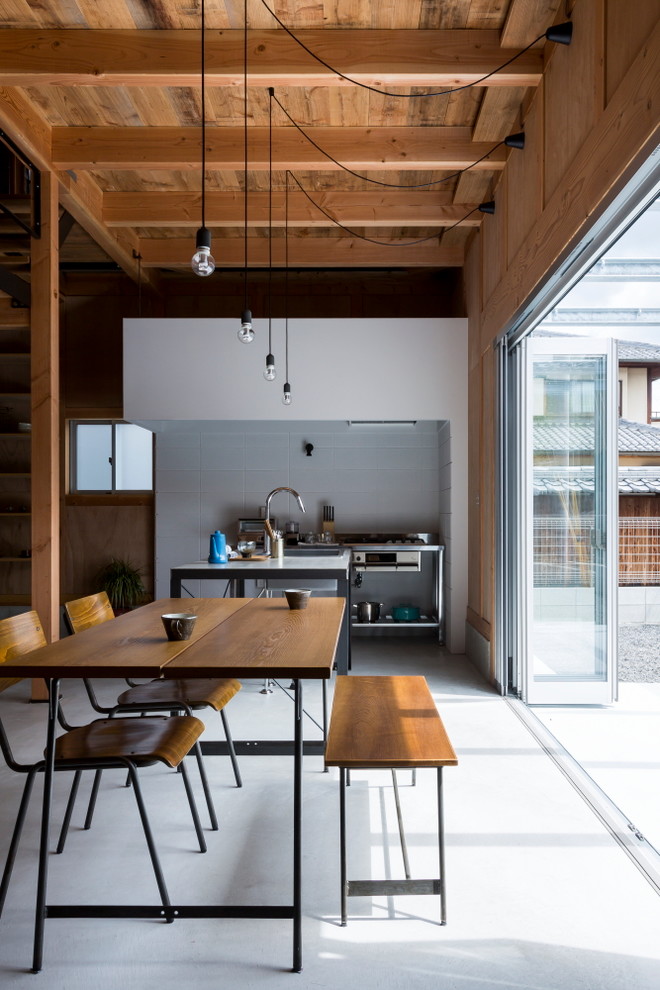 На фото: кухня-столовая среднего размера в стиле лофт с белыми стенами, бетонным полом и серым полом с