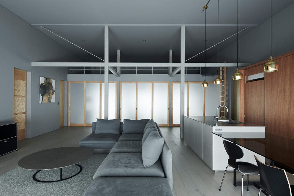 Стильный дизайн: большая гостиная-столовая в стиле модернизм с серыми стенами, паркетным полом среднего тона и серым полом без камина - последний тренд