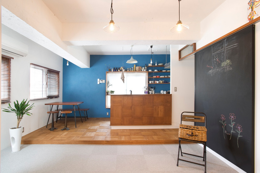Immagine di una sala da pranzo aperta verso la cucina moderna di medie dimensioni con pareti blu, pavimento in legno massello medio e nessun camino