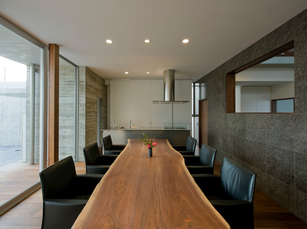 Foto de comedor minimalista con paredes grises y suelo de madera en tonos medios