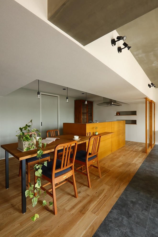 На фото: гостиная-столовая среднего размера в стиле ретро с белыми стенами, полом из керамической плитки и серым полом с