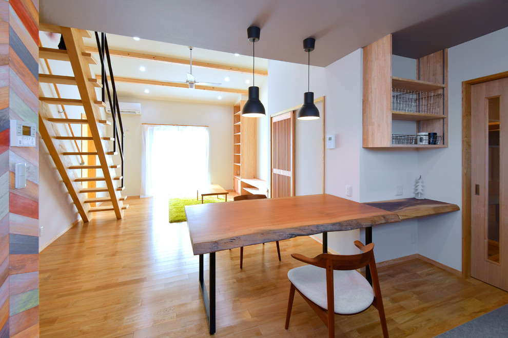 Пример оригинального дизайна: гостиная-столовая в стиле модернизм с белыми стенами, светлым паркетным полом и коричневым полом