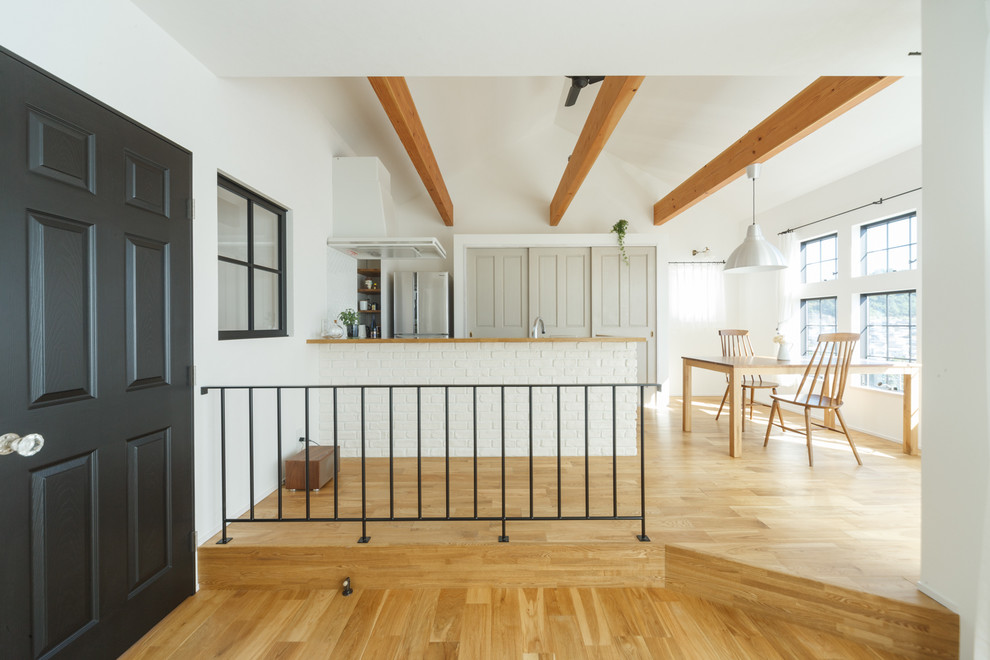 Esempio di una sala da pranzo minimalista con pareti bianche, pavimento in legno massello medio e pavimento marrone