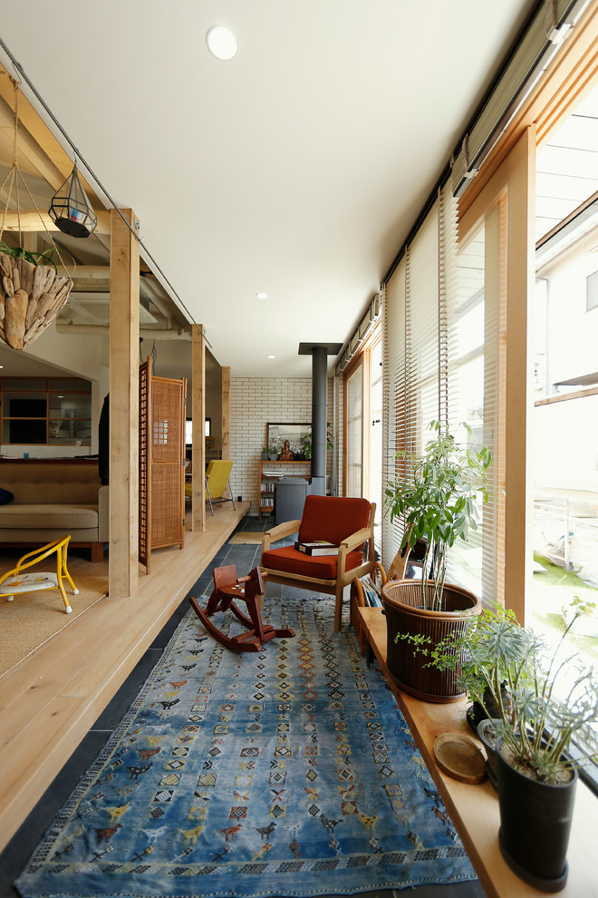 Réalisation d'une salle à manger vintage avec un mur blanc, parquet clair et un poêle à bois.