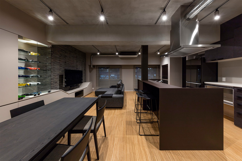Immagine di una sala da pranzo aperta verso il soggiorno moderna con pareti grigie, pavimento in legno verniciato e pavimento marrone