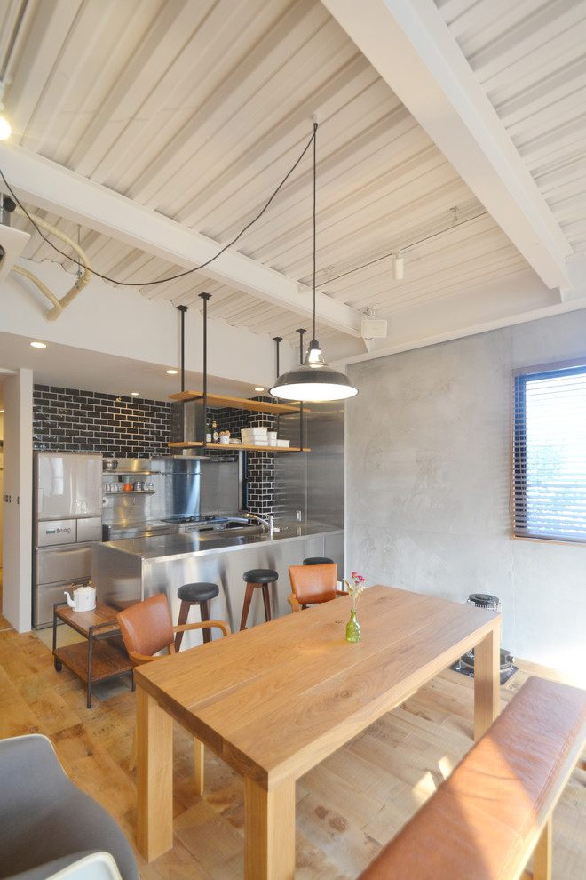 Idee per una sala da pranzo aperta verso la cucina industriale con pareti grigie, parquet chiaro e nessun camino