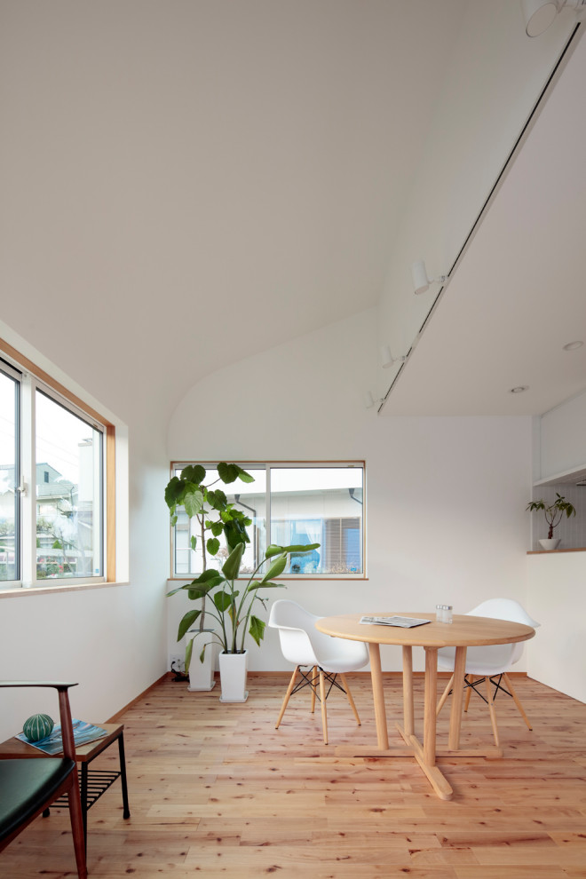 Idéer för en mellanstor minimalistisk matplats med öppen planlösning, med vita väggar, plywoodgolv, en öppen vedspis, en spiselkrans i trä och brunt golv