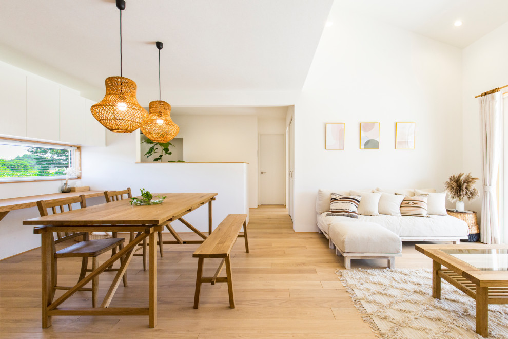 Idee per una sala da pranzo aperta verso il soggiorno stile marinaro con pareti bianche, parquet chiaro, pavimento beige e soffitto a volta