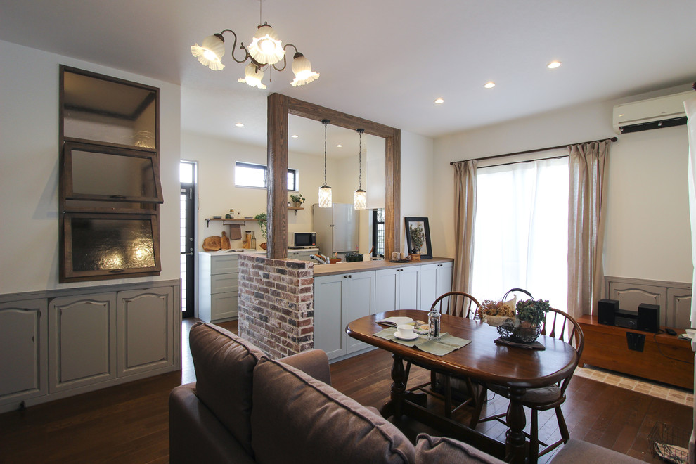 Foto di una sala da pranzo aperta verso il soggiorno nordica di medie dimensioni con pareti bianche e pavimento marrone