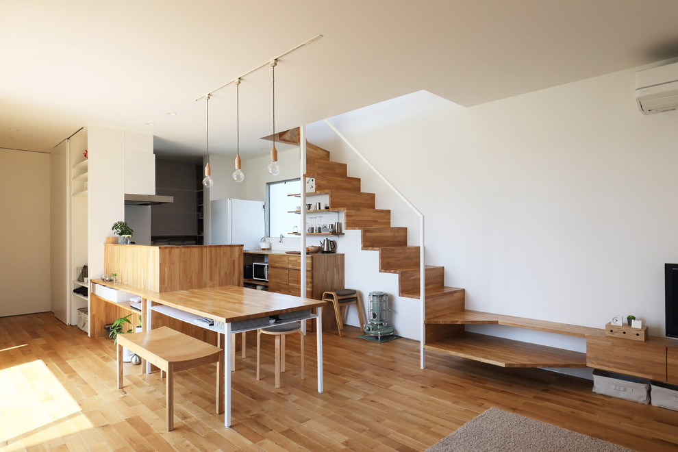 Ispirazione per una sala da pranzo aperta verso il soggiorno design con pareti bianche, pavimento in legno massello medio e pavimento marrone