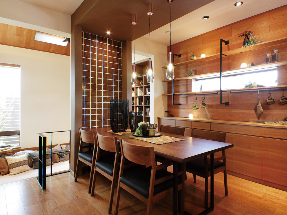 Aménagement d'une salle à manger ouverte sur le salon rétro avec un mur blanc, un sol en bois brun et un sol marron.