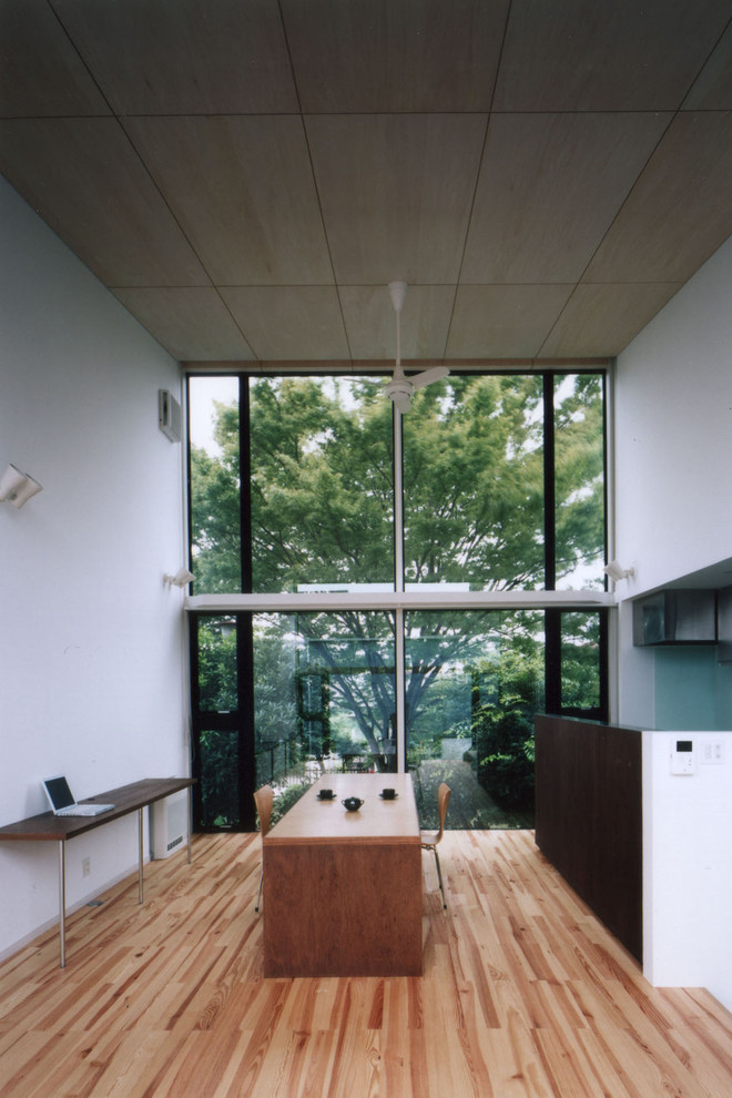 Esempio di una sala da pranzo design con pareti bianche, pavimento in legno massello medio e pavimento marrone