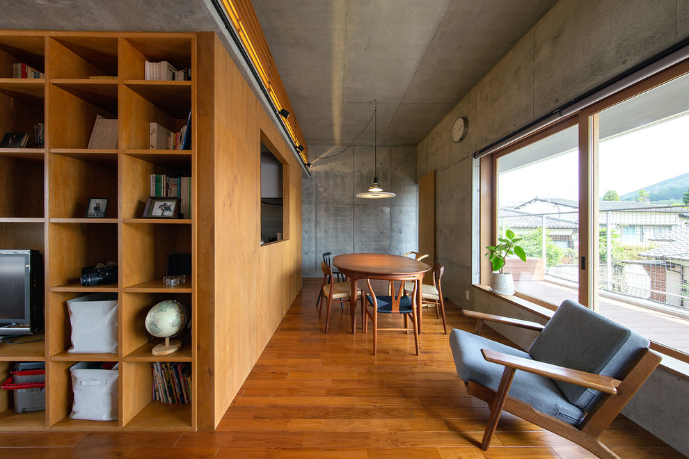 Immagine di una sala da pranzo design con pareti grigie, pavimento in legno massello medio e pavimento marrone