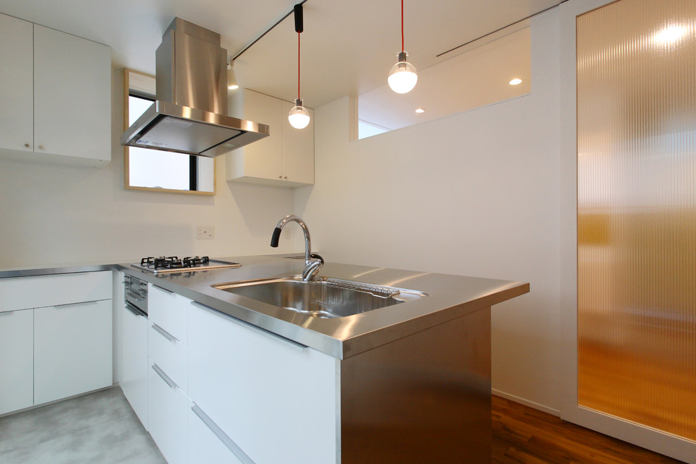 Foto di una cucina abitabile moderna di medie dimensioni con pavimento in legno massello medio e pavimento marrone