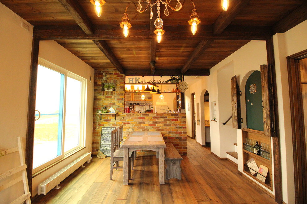 Foto på en medelhavsstil matplats med öppen planlösning, med vita väggar, mellanmörkt trägolv och brunt golv