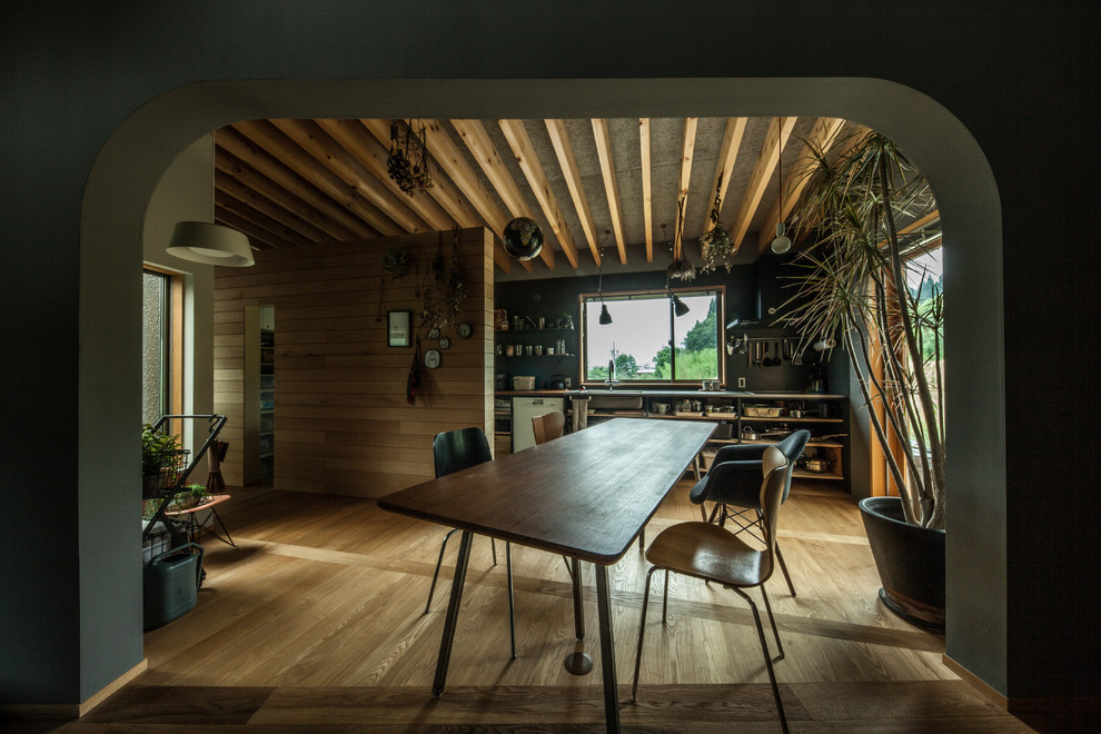 Imagen de comedor contemporáneo abierto con paredes marrones, suelo de madera en tonos medios y suelo marrón