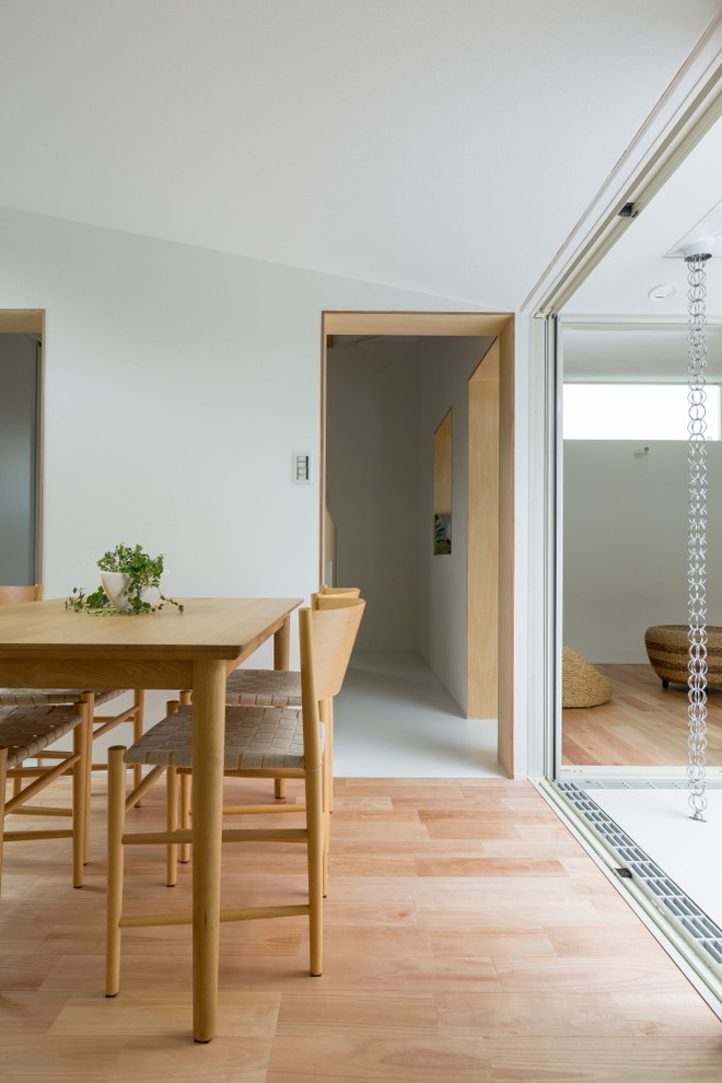 Immagine di una piccola sala da pranzo aperta verso la cucina scandinava con pareti bianche, pavimento in vinile e pavimento bianco