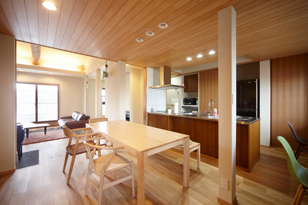 Ispirazione per una sala da pranzo aperta verso il soggiorno scandinava con pareti bianche, pavimento in legno massello medio e pavimento marrone