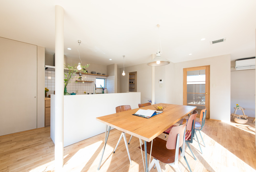 Idee per una sala da pranzo aperta verso il soggiorno nordica con pareti bianche, parquet chiaro e pavimento marrone