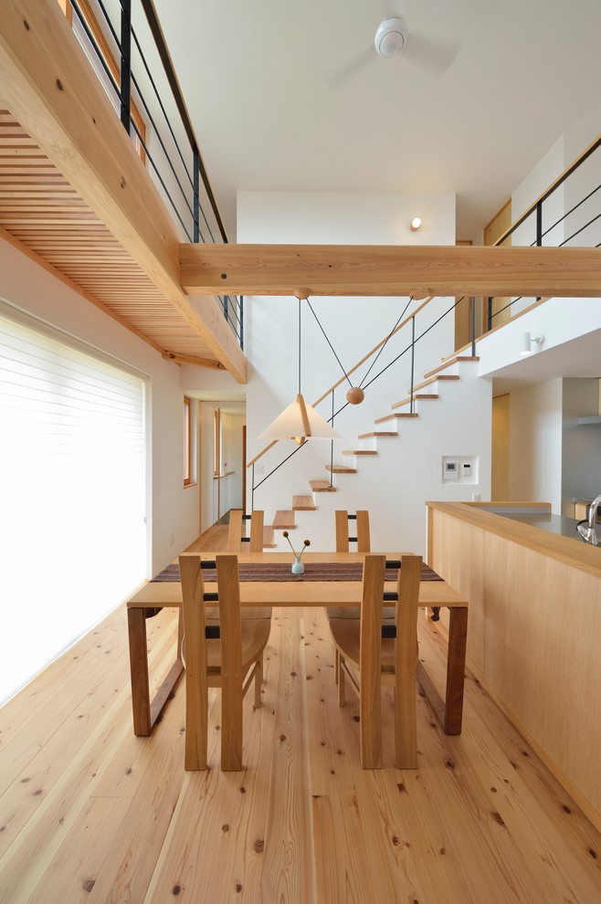 Esempio di una sala da pranzo etnica con pareti bianche, pavimento in legno massello medio e pavimento marrone