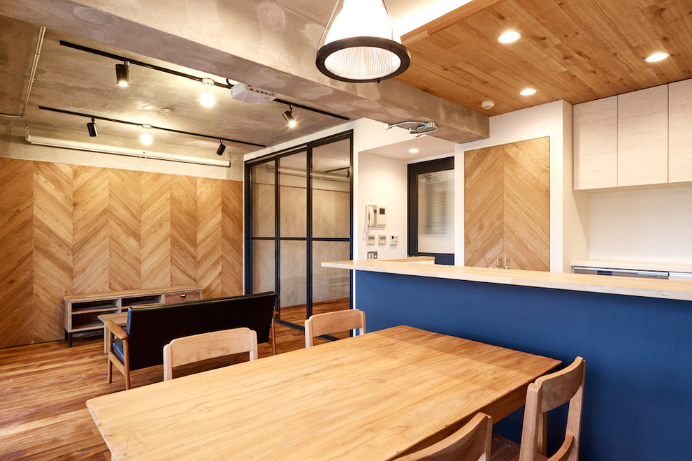 Exemple d'une salle à manger ouverte sur le salon industrielle avec un mur blanc, parquet foncé et un sol multicolore.