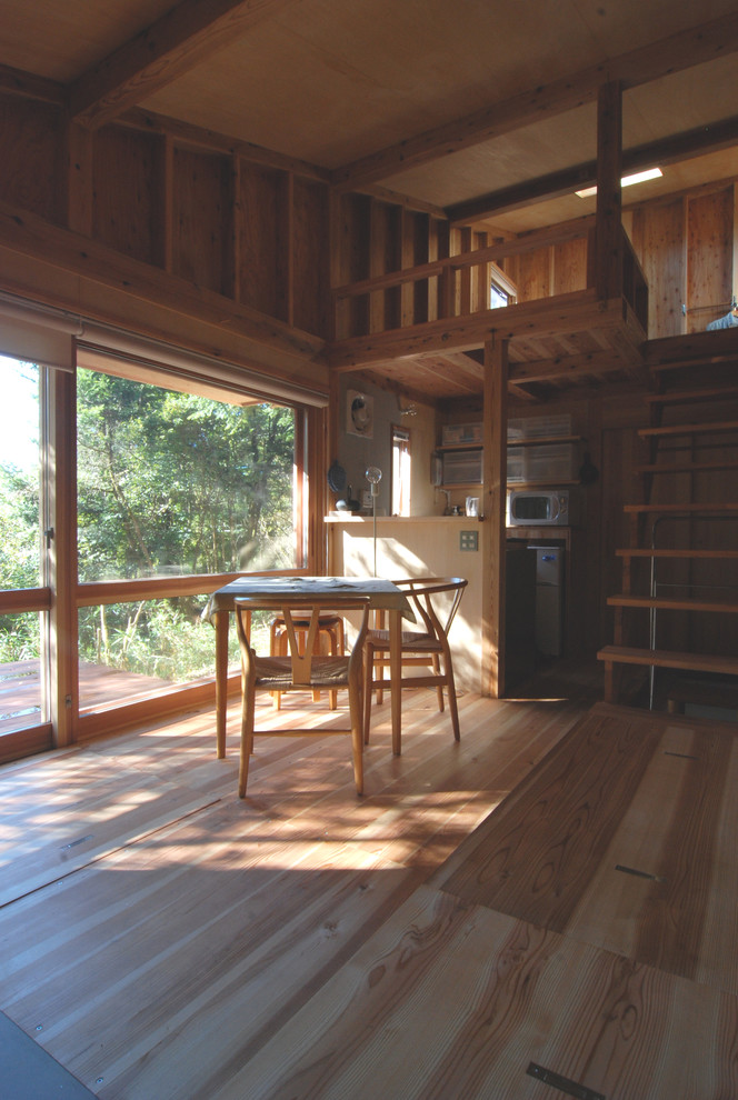 Cette image montre une petite salle à manger ouverte sur le salon chalet avec un sol en contreplaqué.