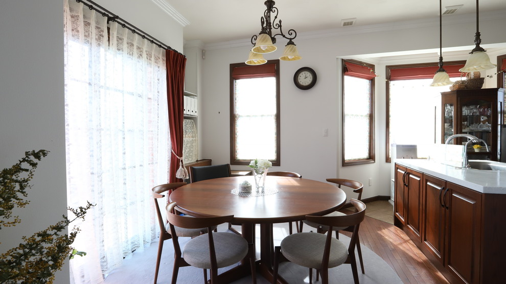 Источник вдохновения для домашнего уюта: столовая в стиле неоклассика (современная классика) с белыми стенами, темным паркетным полом и коричневым полом