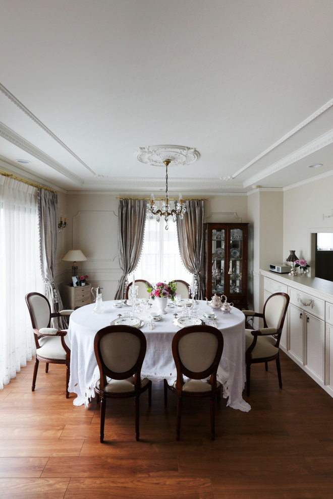 Ispirazione per una sala da pranzo vittoriana chiusa con pareti beige, pavimento in legno massello medio e pavimento marrone