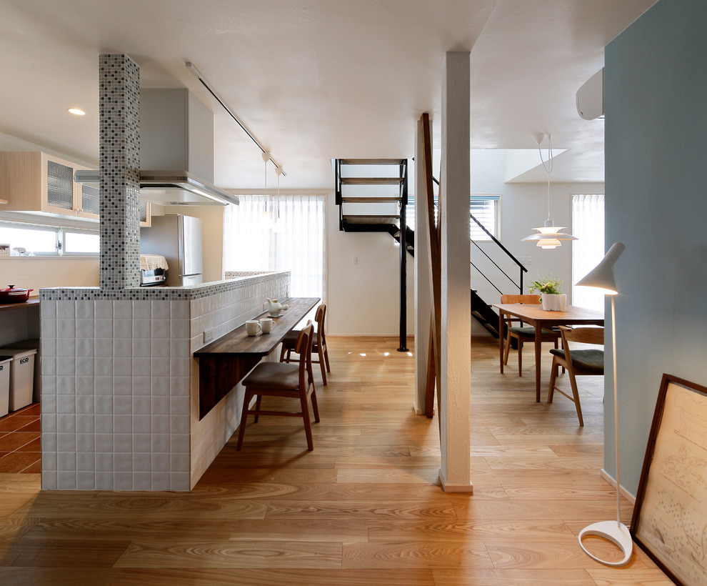 Immagine di una sala da pranzo aperta verso il soggiorno scandinava con pareti multicolore, pavimento in legno massello medio e pavimento marrone