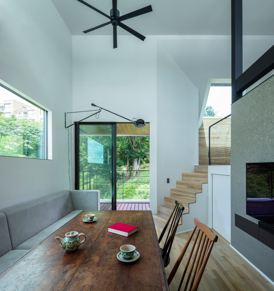 Modernes Esszimmer mit weißer Wandfarbe, hellem Holzboden und beigem Boden in Sonstige