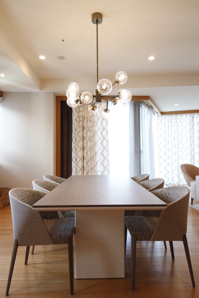 Immagine di una sala da pranzo aperta verso la cucina design di medie dimensioni con pareti grigie, pavimento in bambù, nessun camino e pavimento arancione