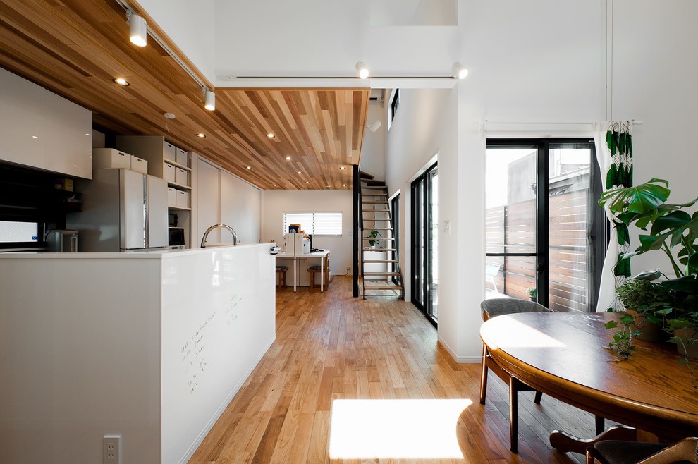 Foto di una sala da pranzo design con pareti bianche, pavimento in legno massello medio e pavimento marrone