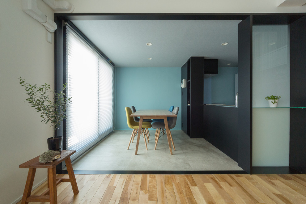 Idées déco pour une salle à manger contemporaine avec un mur bleu, sol en béton ciré et un sol gris.