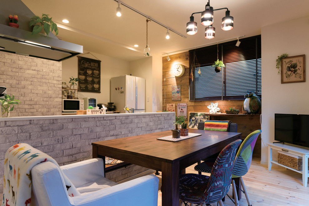 Immagine di una sala da pranzo aperta verso la cucina country con pareti bianche, parquet chiaro, soffitto in carta da parati e carta da parati