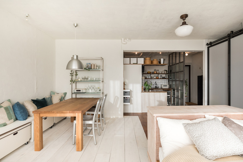 Пример оригинального дизайна: маленькая гостиная-столовая в современном стиле с белыми стенами, деревянным полом и разноцветным полом для на участке и в саду