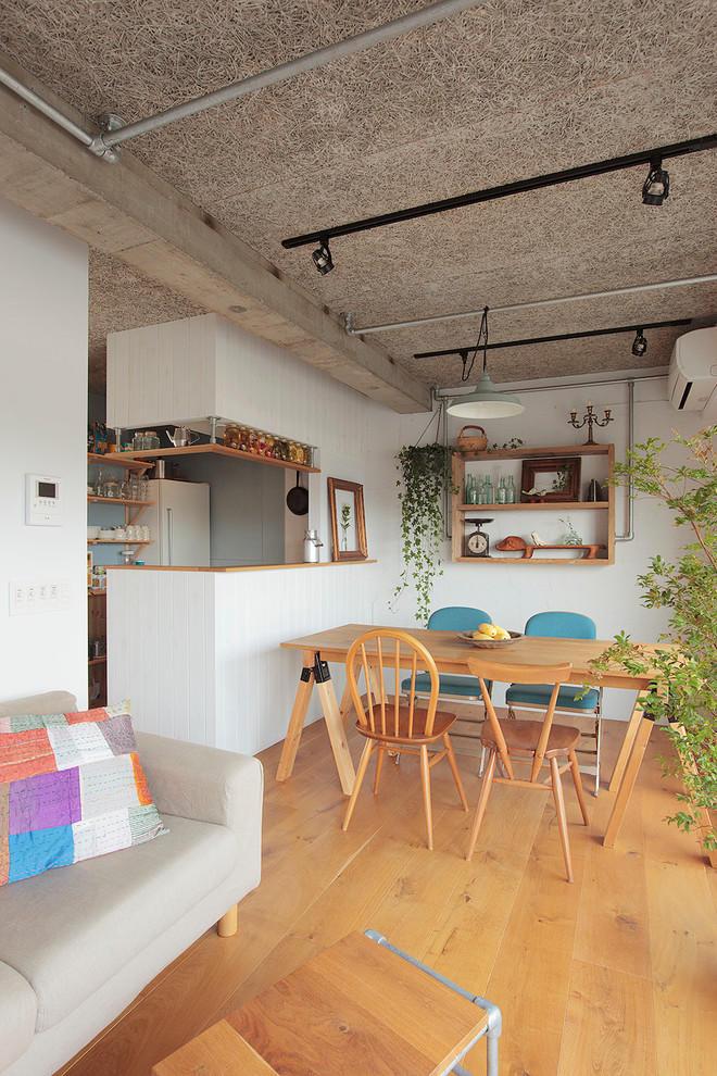 Aménagement d'une salle à manger ouverte sur le salon classique avec un mur blanc, aucune cheminée et un sol en bois brun.
