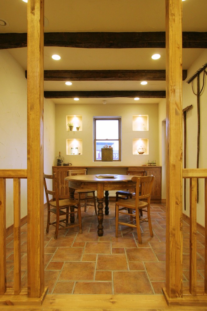 Источник вдохновения для домашнего уюта: отдельная столовая в стиле кантри с бежевыми стенами, полом из терракотовой плитки и коричневым полом