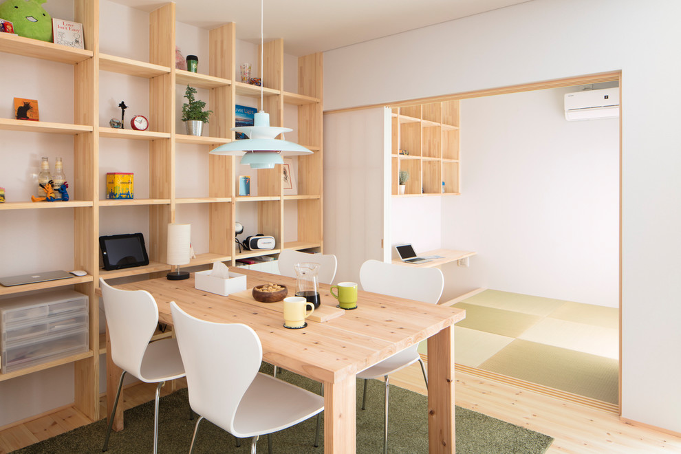 Imagen de comedor contemporáneo abierto con paredes blancas, suelo de madera en tonos medios y suelo marrón