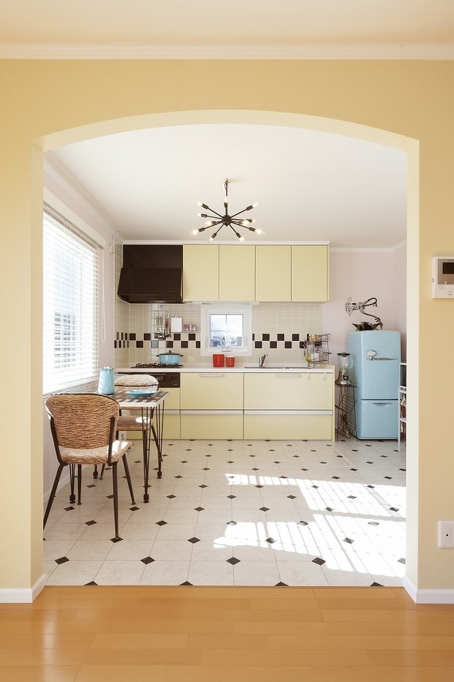 Aménagement d'une salle à manger ouverte sur la cuisine exotique avec un mur rose, un sol en carrelage de céramique et un sol multicolore.