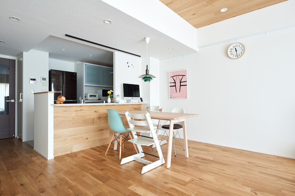 Imagen de comedor nórdico abierto con suelo de madera en tonos medios