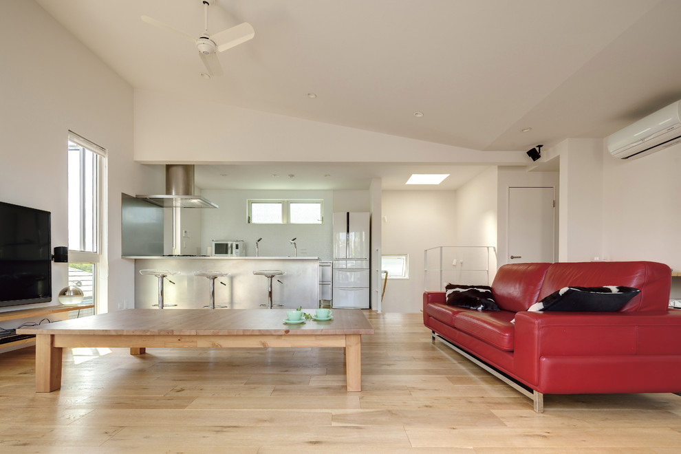 Foto di una sala da pranzo aperta verso il soggiorno contemporanea con pareti bianche, parquet chiaro e pavimento beige
