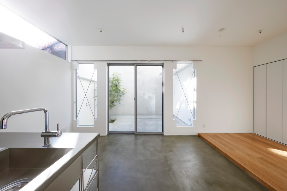 Foto di una piccola sala da pranzo aperta verso il soggiorno moderna con pareti bianche, pavimento in cemento, soffitto in carta da parati e carta da parati