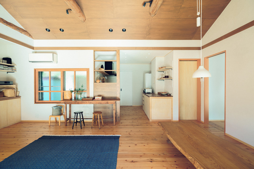 Offenes Asiatisches Esszimmer mit weißer Wandfarbe, braunem Holzboden und braunem Boden in Nagoya