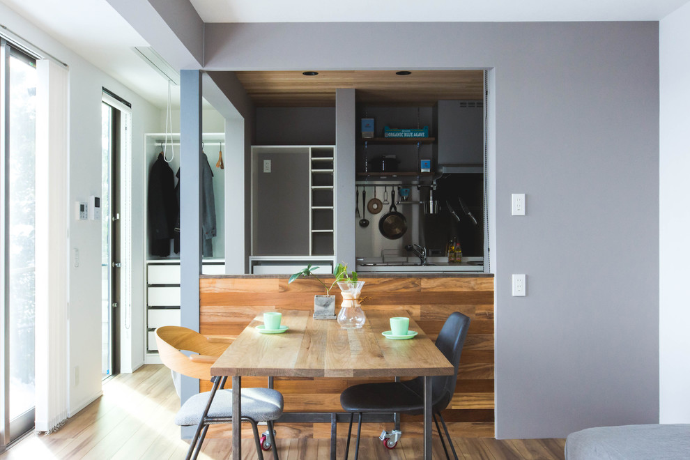 Immagine di una piccola sala da pranzo moderna con pareti grigie, pavimento in compensato e pavimento marrone