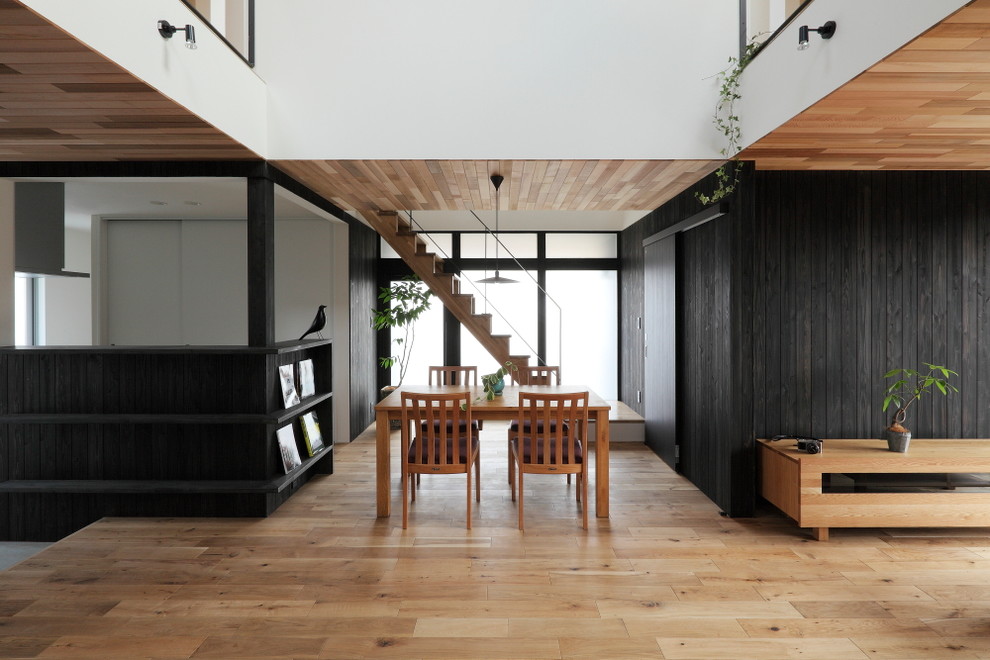 Esempio di una sala da pranzo etnica di medie dimensioni con pareti nere, pavimento in legno massello medio e pavimento beige
